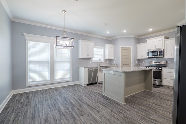 kitchen featuring a sink, tasteful backsplash, a kitchen island, appliances with stainless steel finishes, and dark wood-style flooring