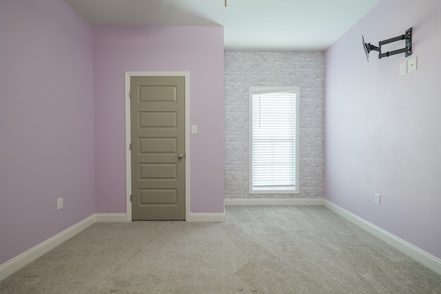 spare room featuring baseboards and carpet floors