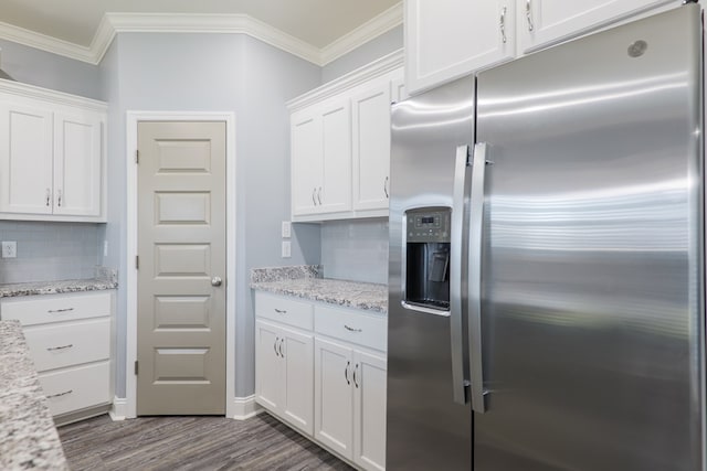 kitchen with stainless steel fridge, dark wood-type flooring, ornamental molding, and white cabinetry