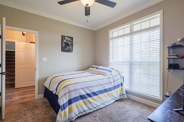 carpeted bedroom with ceiling fan and ornamental molding