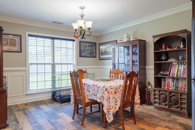 dining room with crown molding, a chandelier, and dark hardwood / wood-style floors