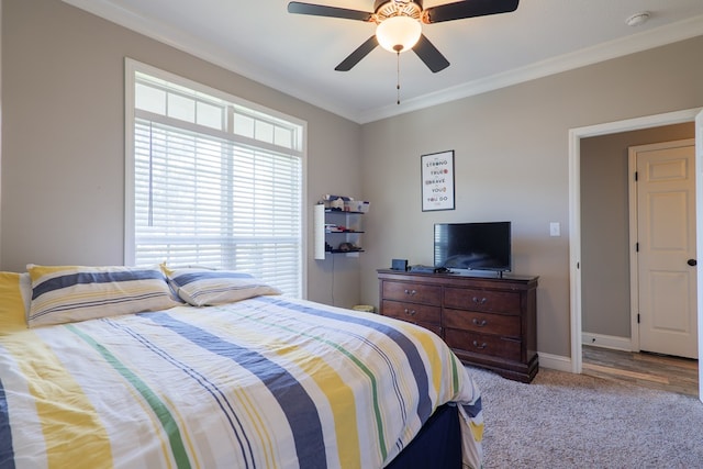 carpeted bedroom featuring ceiling fan and ornamental molding