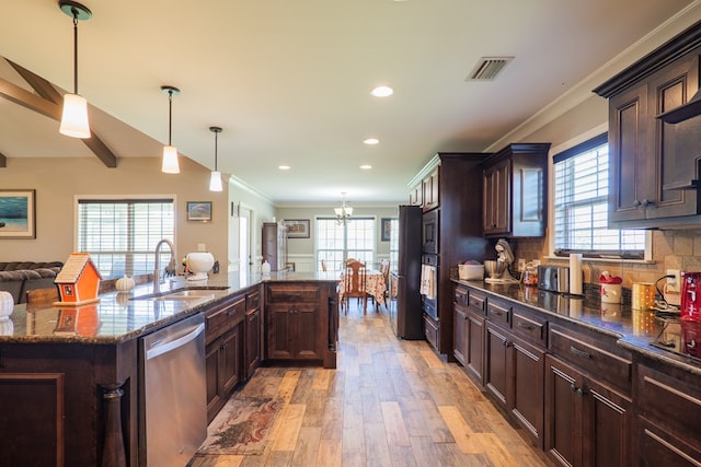 kitchen featuring dishwasher, sink, hanging light fixtures, and an island with sink