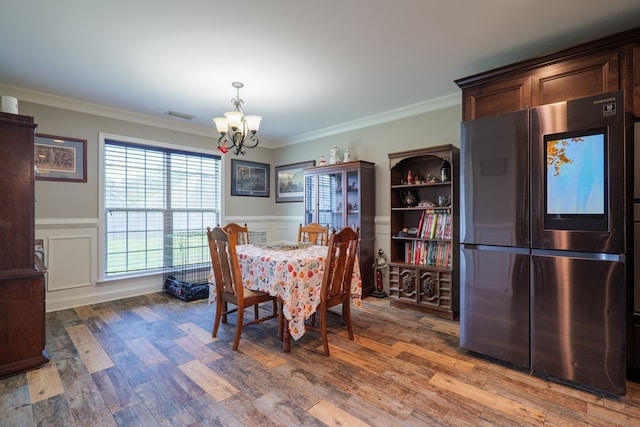 dining room featuring a chandelier, hardwood / wood-style flooring, and crown molding