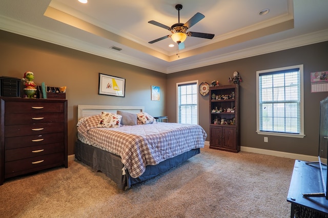 carpeted bedroom featuring a raised ceiling, ceiling fan, and ornamental molding