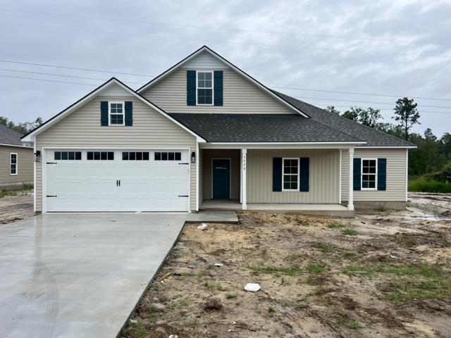 view of front facade featuring a porch, concrete driveway, roof with shingles, and a garage