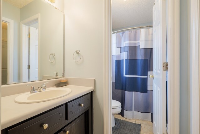 full bathroom featuring tile patterned floors, toilet, a textured ceiling, a shower with shower curtain, and vanity