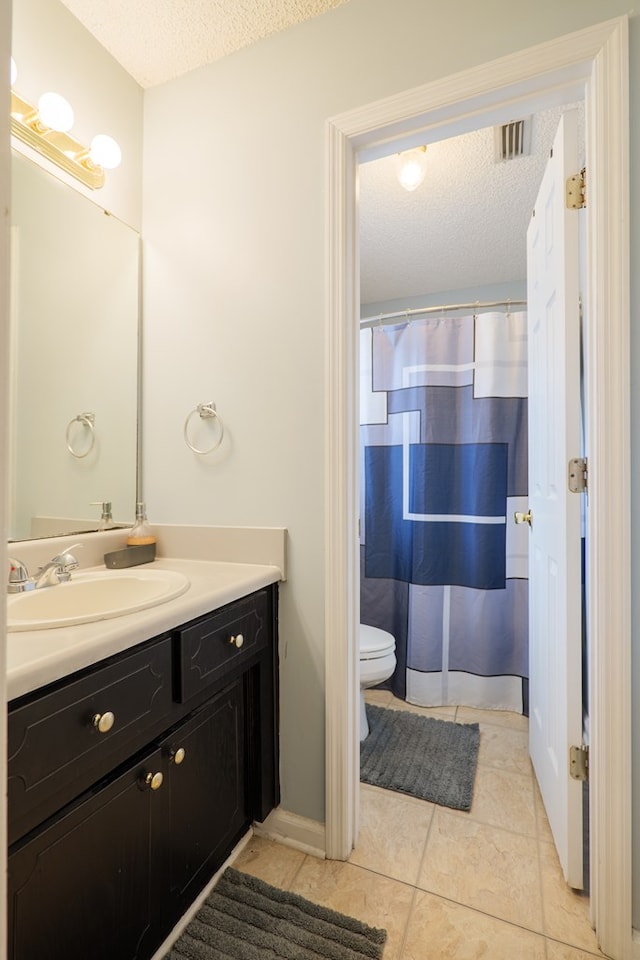 bathroom with tile patterned flooring, toilet, visible vents, and a textured ceiling