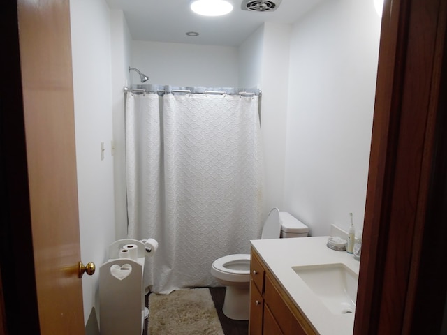 bathroom featuring curtained shower, vanity, and toilet