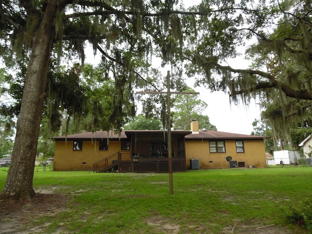 back of property featuring central AC, a sunroom, and a yard