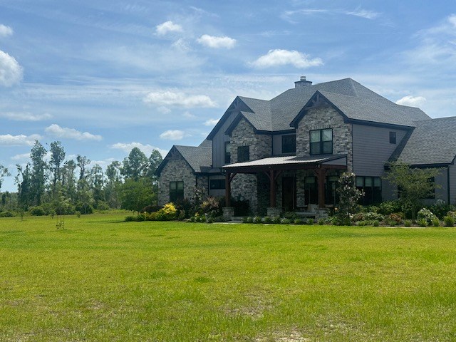 35 Tyler Rd, Naylor, GA 31641 - view of side of property featuring stone siding, a lawn, a chimney, and a porch