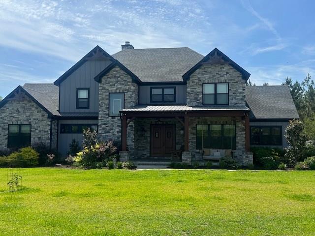 35 Tyler Rd, Naylor, GA 31641 - view of front facade with board and batten siding, stone siding, a porch, and a front yard