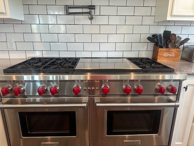 35 Tyler Rd, Naylor, GA 31641 - kitchen view of range with two ovens, decorative backsplash, and white cabinetry