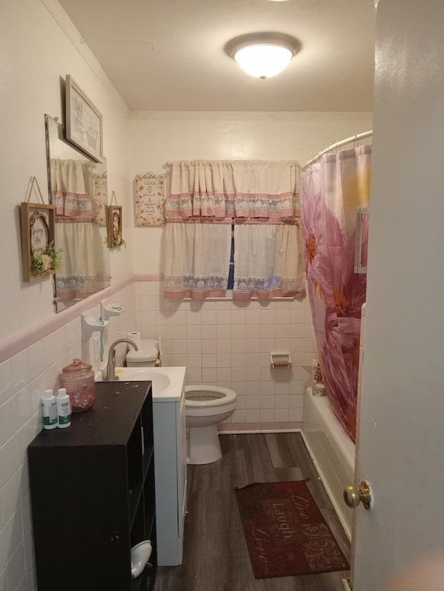 full bathroom featuring toilet, shower / tub combo with curtain, vanity, tile walls, and hardwood / wood-style flooring