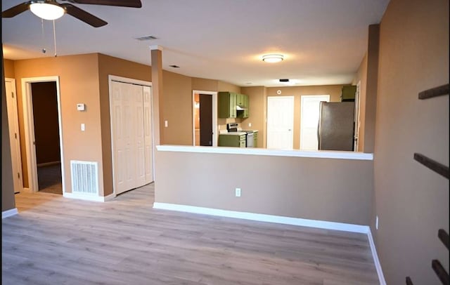 unfurnished room with light wood-style floors, visible vents, baseboards, and a ceiling fan