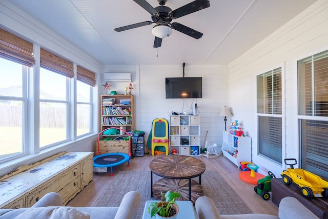 4809 Brown Cat Cir, Hahira, GA 31632 - living area with wood finished floors, a wall unit AC, a ceiling fan, and wooden walls