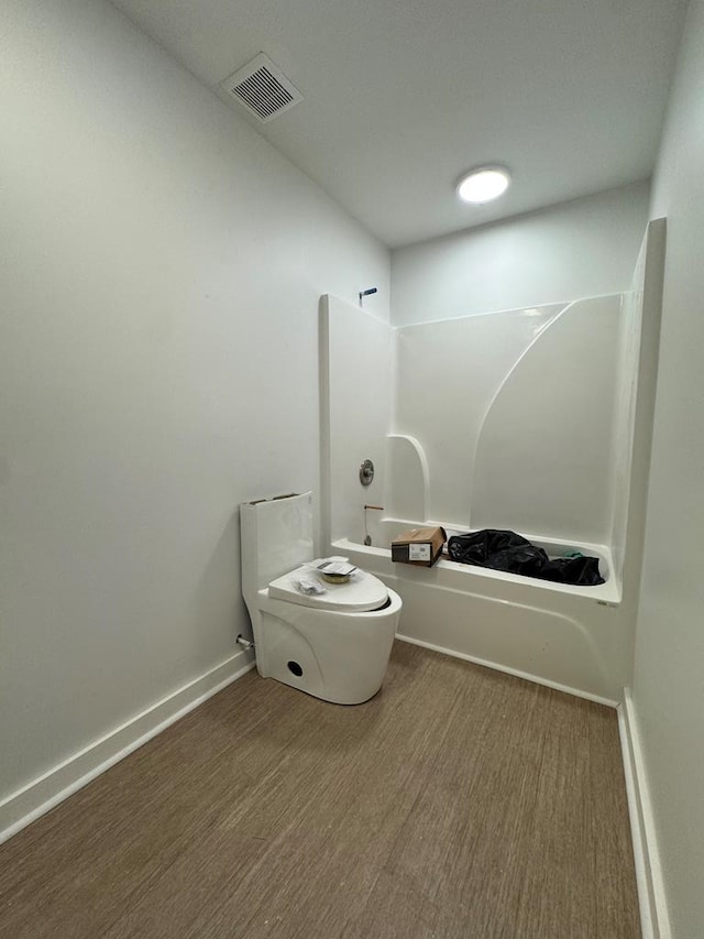 full bathroom with visible vents, baseboards, toilet, shower / bathtub combination, and wood finished floors