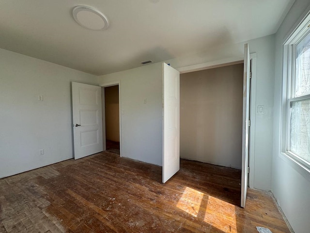 unfurnished bedroom featuring visible vents and wood finished floors