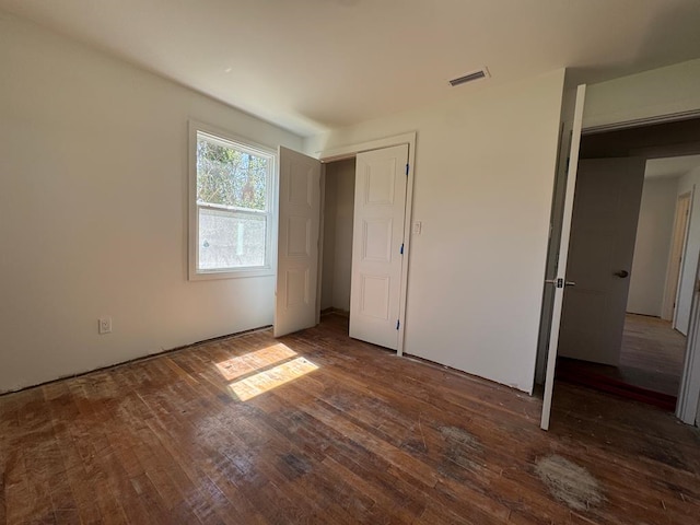 unfurnished bedroom featuring visible vents and wood-type flooring