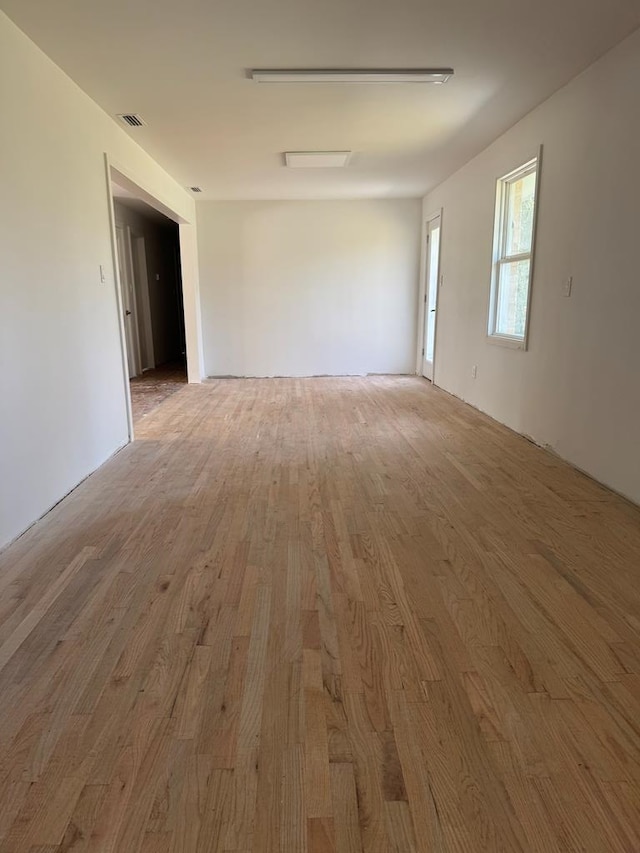 empty room with wood finished floors and visible vents