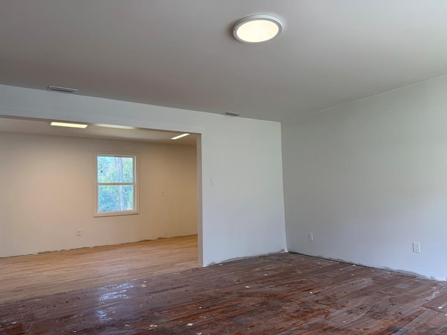 spare room with wood finished floors and visible vents