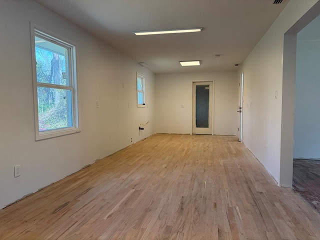 empty room featuring visible vents and light wood-type flooring