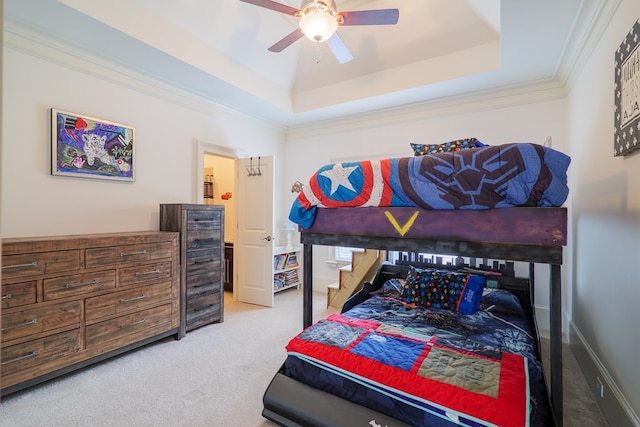 bedroom with a tray ceiling, ornamental molding, light colored carpet, and ceiling fan