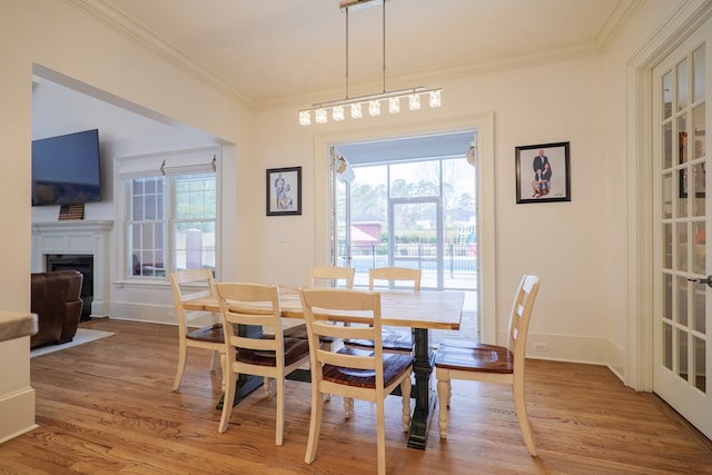 dining space with ornamental molding, a wealth of natural light, and light wood-type flooring