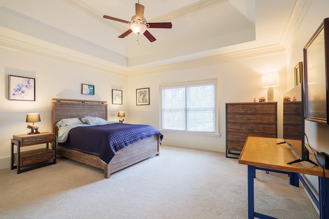 bedroom with crown molding, light carpet, ceiling fan, and a tray ceiling