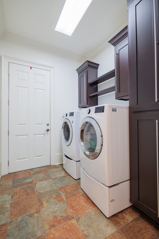 laundry area with cabinets, washing machine and dryer, and crown molding