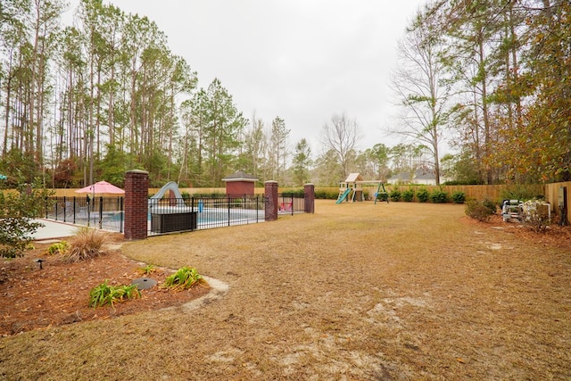 view of yard with a community pool and a playground