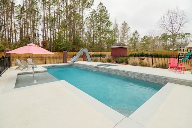 view of swimming pool with a playground, a water slide, a jacuzzi, and a patio area