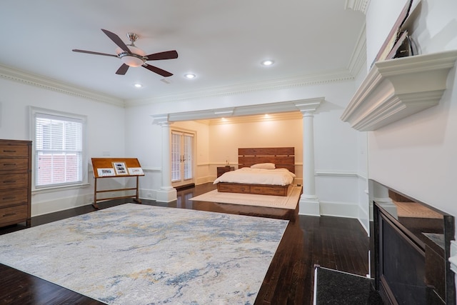 bedroom featuring dark wood-type flooring, ceiling fan, ornamental molding, and decorative columns