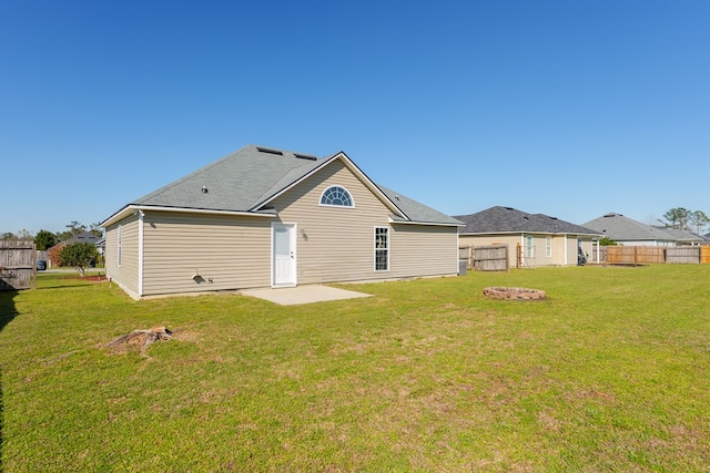 rear view of house with a yard and fence