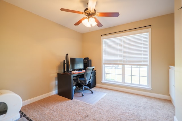 carpeted home office with ceiling fan and baseboards