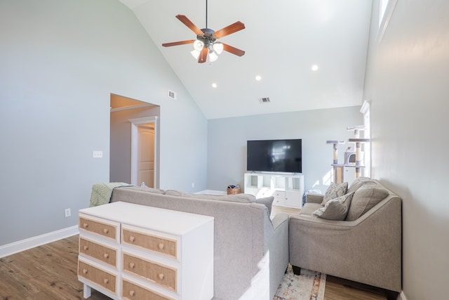 living area featuring a ceiling fan, wood finished floors, visible vents, high vaulted ceiling, and baseboards