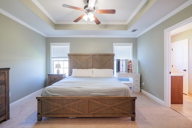 bedroom with a tray ceiling, light carpet, baseboards, and visible vents