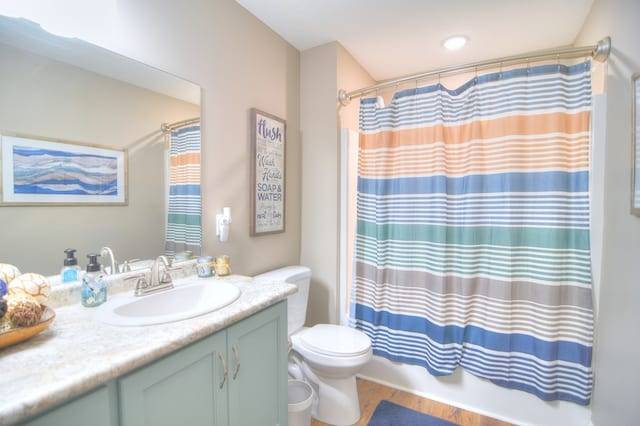 bathroom with toilet, vanity, shower / tub combo, and wood finished floors