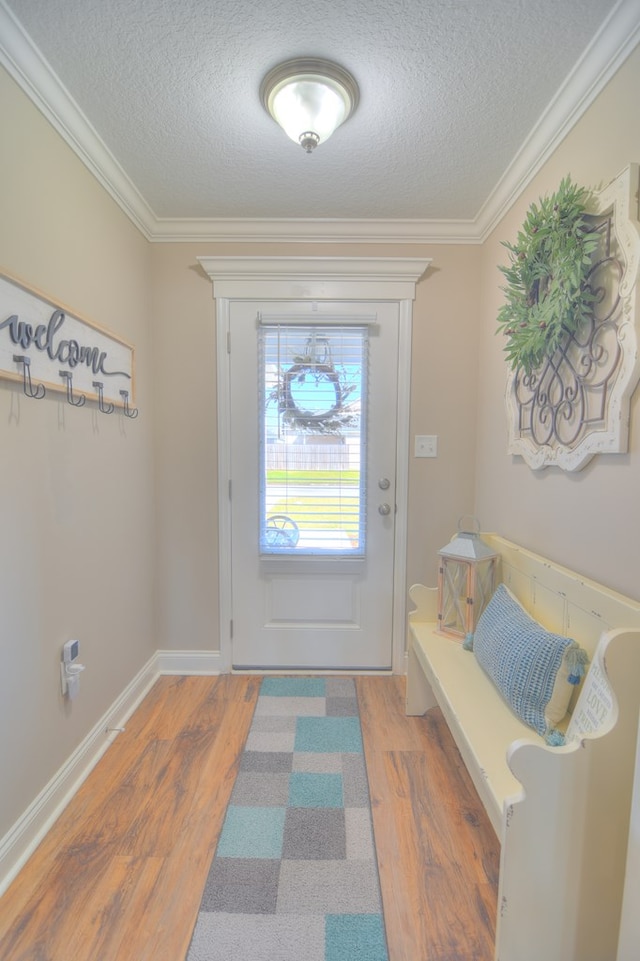 doorway featuring ornamental molding, a textured ceiling, and wood finished floors