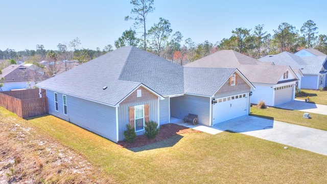 view of front of home featuring concrete driveway, an attached garage, fence, and a front yard