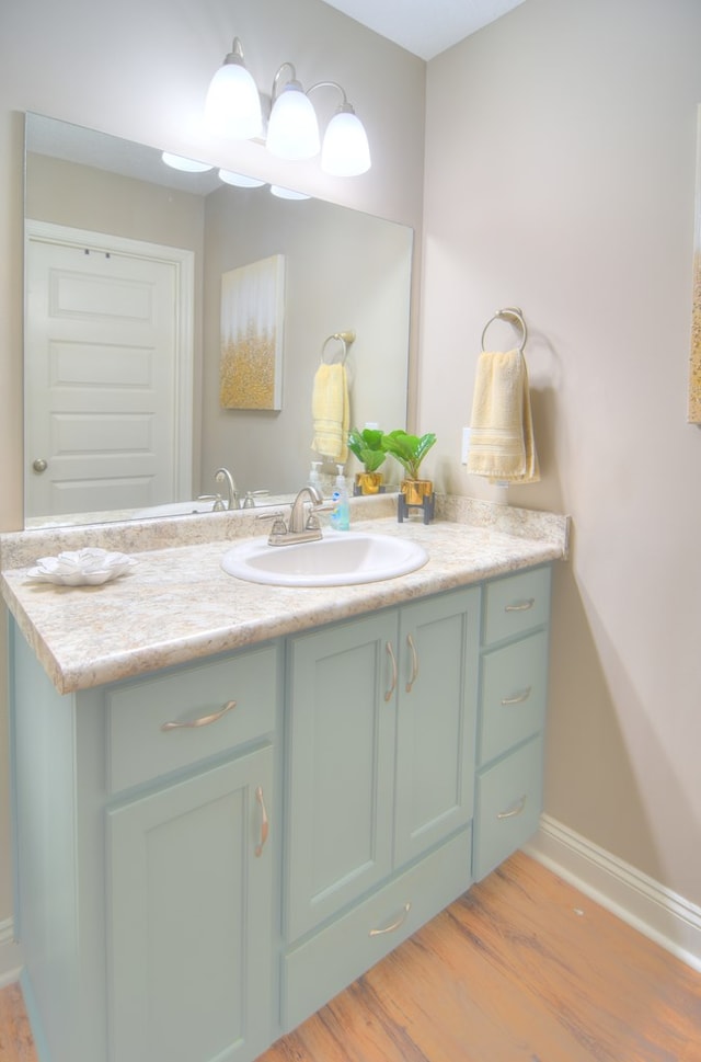 bathroom with vanity, baseboards, and wood finished floors