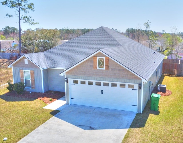 view of front of property with a front yard, cooling unit, fence, a shingled roof, and a garage