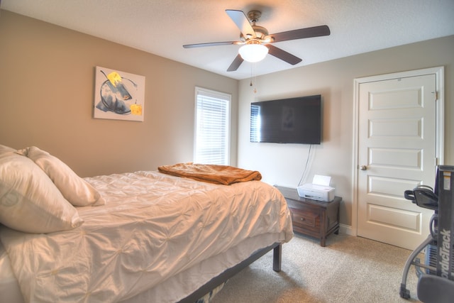 bedroom with a textured ceiling, a ceiling fan, and light carpet