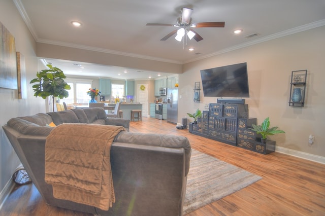 living room featuring visible vents, crown molding, baseboards, light wood-type flooring, and recessed lighting