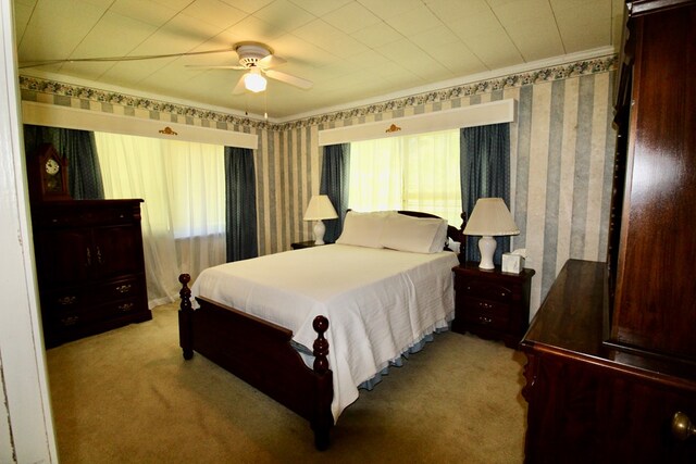 bedroom with ceiling fan, light colored carpet, and crown molding