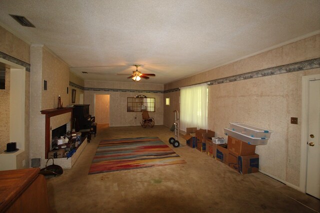 carpeted living room with ceiling fan, a textured ceiling, and ornamental molding