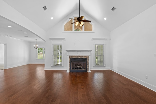 unfurnished living room featuring visible vents, a stone fireplace, dark wood-type flooring, and high vaulted ceiling