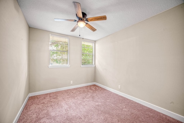 spare room featuring a textured ceiling, carpet floors, ceiling fan, and baseboards