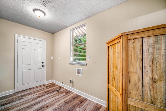 laundry room with hookup for a washing machine, visible vents, wood finished floors, laundry area, and baseboards