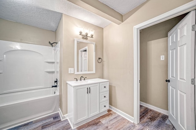 full bathroom featuring shower / bath combination, vanity, a textured ceiling, wood finished floors, and baseboards